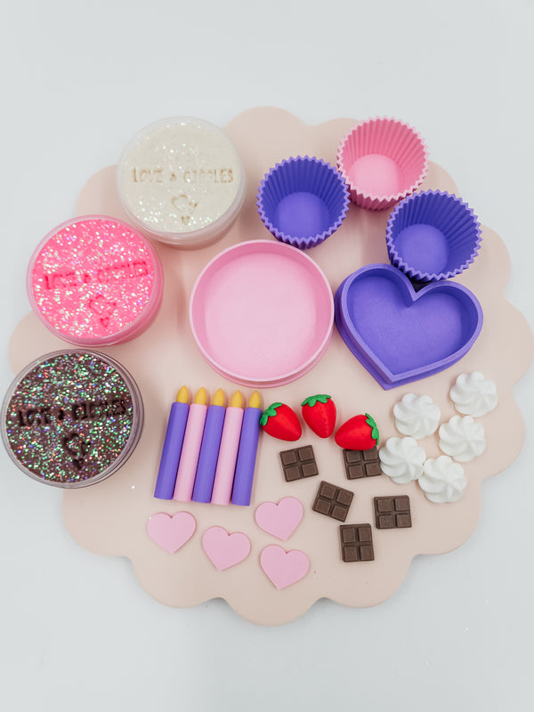 Happy Birthday playdough kit with glitter dough jars, cupcake molds, birthday candles, strawberry and chocolate toppers, and heart-shaped decorations
