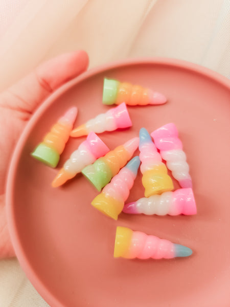Colorful unicorn play accessories on a pink plate 