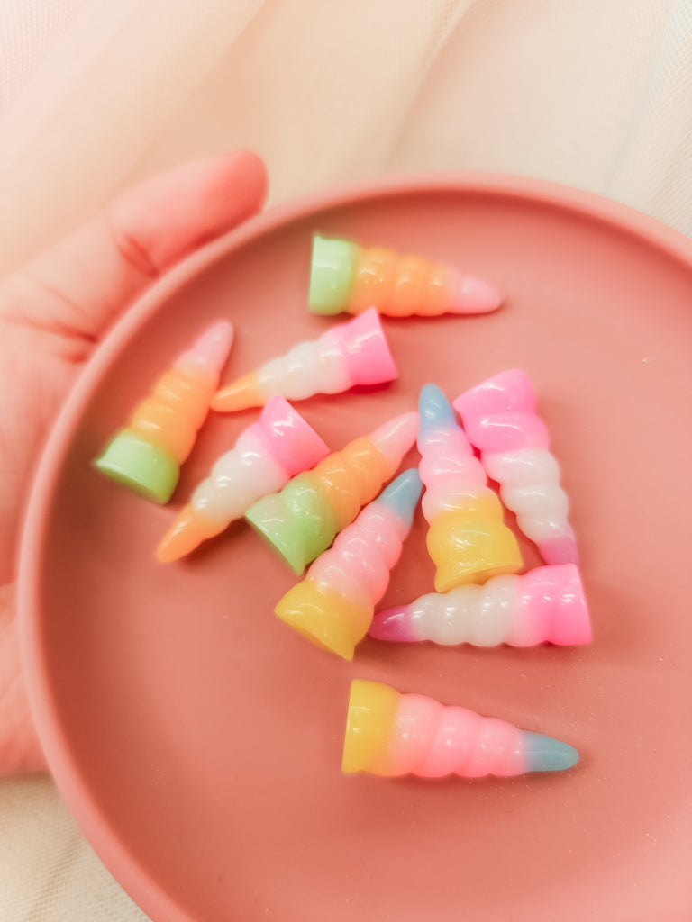 Colorful unicorn play accessories on a pink plate 