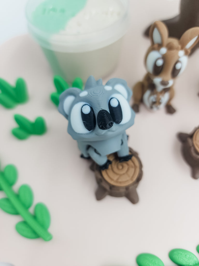 koala figurine on tree stump